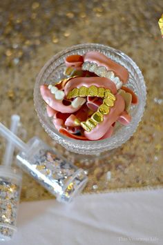 a glass bowl filled with pink and gold candies