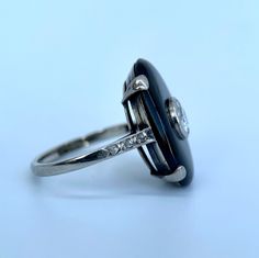 An exceptionally scintillating diamond and onyx cocktail ring. 18K white gold cocktail ring featuring an oval onyx cabochon, approx. 0.40 carats of old European cut diamond and rose cut diamonds at shank. Hallmark: No Hallmark, Tested for 18K Purity Metal Type: 18K White Gold Total Item Weight (g): 5.0 Clarity Grade: SI1 Gemstone: Diamond Fluorescence: Faint Stone Shape: Old European Cut Color Grade: H-I Carat Weight: 0.4 Stone Dimensions (mm): Avg. Diameter 1.05 Clarity Grade: Slightly Included Amethyst And Diamond Ring, Diamond Cocktail Ring, G 5, Gold Cocktail Ring, Gold Cocktail, Diamond Cocktail Rings, Moonstone Necklace, European Cut Diamonds, Rose Cut Diamond