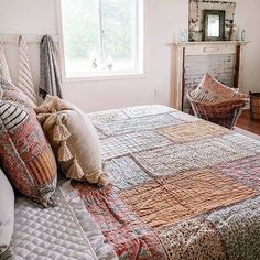 a bed in a bedroom with pillows and blankets on top of the bedspread