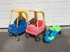 three children's toy cars sitting next to each other in front of a garage door