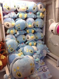 several stuffed animals are on display in a store window and one is blue with yellow eyes