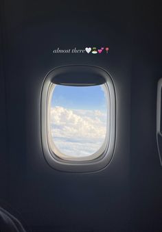 an airplane window with the words almost there on it and clouds in the sky below