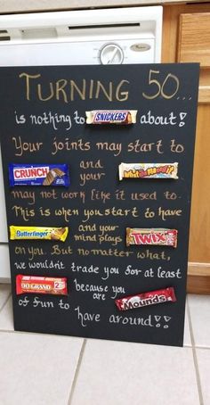 a chalk board with candy bars written on it in front of a dishwasher