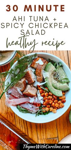 a white plate topped with meat, beans and avocado on top of a wooden table