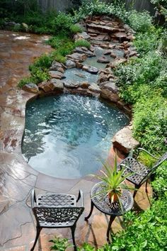 an outdoor hot tub in the middle of a garden