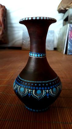 a brown vase sitting on top of a wooden floor