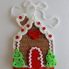 a crocheted christmas ornament hanging on a wall with a red door