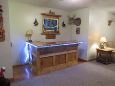 a living room filled with furniture and christmas lights on the wall next to a bar