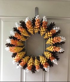 a wreath made out of fake leaves hangs on the front door to give it an autumn feel