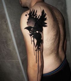 a man with a black ink tattoo on his arm and shoulder is standing in front of a mirror