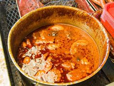 a pot filled with food sitting on top of a grill