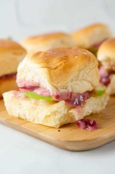 small sandwiches are sitting on a wooden plate