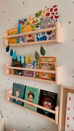 three wooden bookshelves holding children's books in a child's room