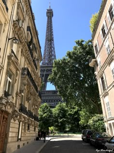 the eiffel tower towering over the city of paris, france as seen from between two buildings