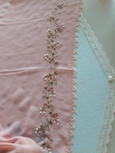 a close up of a piece of cloth with flowers on it and lace around the edges