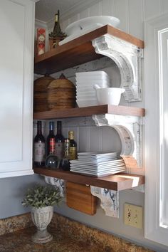 the shelves in the kitchen are filled with dishes and wine bottles, plates and bowls