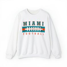 Are you ready for FOOTBALL SEASON?! And are you looking for a unique, retro design that differs from the generic team gear you find elsewhere online? This vintage styled, cute Miami Football sweatshirt is perfect to support your Miami Dolphin this football season! This crewneck is available in white, ash grey, sport grey, heather grey, sand, and black (pick one up for your husband/boyfriend/best friend/dad/mom etc too!) Sweatshirt details are below, and the models in the pictures are wearing lar Team Spirit Logo Print Sweatshirt For Game Day, Team Spirit Sweatshirt With Logo Print For Game Day, Retro Tops For Football Season Streetwear, Retro Tops For Streetwear During Football Season, Collegiate Team-colored Sweatshirt With Logo, Collegiate Sweatshirt With Team Logo Print, Varsity Crew Neck Top For Football Season, Collegiate Graphic Print Sweatshirt For Fans, Collegiate Graphic Print Sweatshirt For Fan Merchandise