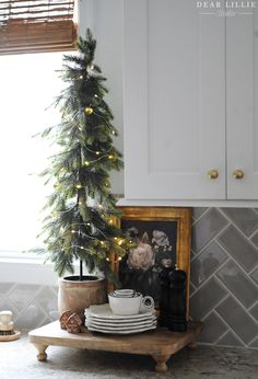 a small christmas tree in the corner of a kitchen