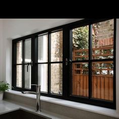 a kitchen sink sitting under a window next to a potted plant