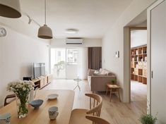 a living room filled with furniture next to a dining table and tv on top of a hard wood floor