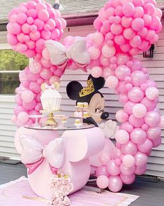 a minnie mouse balloon arch with pink balloons