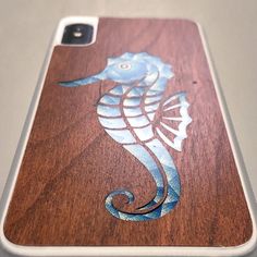 a wooden phone case with a sea horse on it