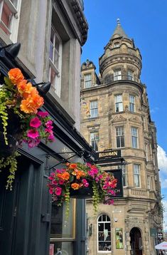 an old building with flowers hanging from it's side