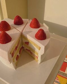 a white cake with strawberries cut in half