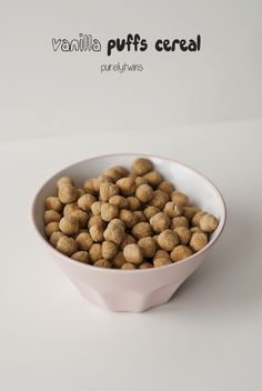 a white bowl filled with dry food on top of a white table next to the words vanilla puffs cereal