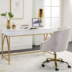 a white desk with gold accents and a chair in front of the window, next to a potted plant