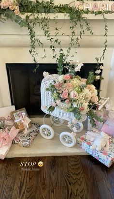 a baby carriage with flowers and gifts in front of the fire place at a birthday party