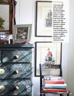 an old dresser with pictures on the wall next to it