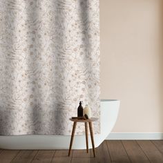 a white vase sitting on top of a wooden table in front of a shower curtain