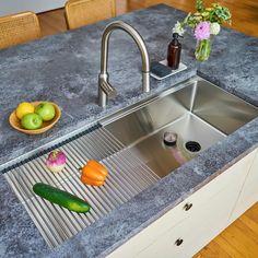 a stainless steel sink in a kitchen with vegetables on the counter