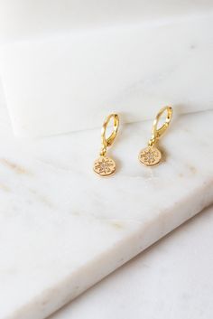 Our Starburst Pendant Huggie Earrings are the perfect minimalist earrings! Made with 14K Gold Filled findings, nickle and lead free. These simple earrings are a beautiful staple piece! Everyday Yellow Gold Earrings With Star Charm, Dainty 14k Gold Star Charm Earrings, Dainty 14k Gold Earrings With Star Charm, Dainty Gold-plated Earrings With Star Charm, Dainty Gold Plated Earrings With Star Charm, Dainty Gold Earrings With Star Charm, Gold Round Earrings With Star Charm, Minimalist 14k Gold Star Charm Earrings, Minimalist 14k Gold Earrings With Star Charm