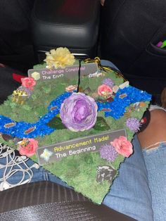 a decorated graduation cap with flowers on it sitting in the back seat of a car