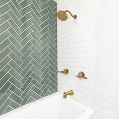 a white bath tub sitting under a faucet next to a wall mounted shower head