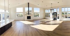 an empty room with large windows and wooden floors