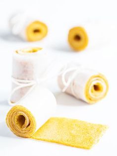 three rolls of yellow and white paper next to each other