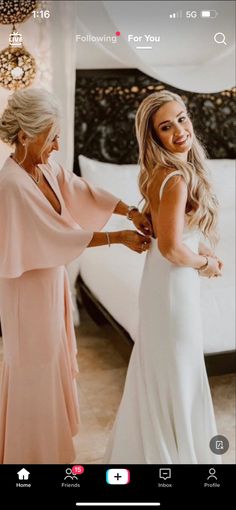 a woman in a wedding dress is helping another woman get dressed