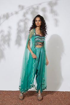 Aqua bustier embroidered with thread, tubes, pearls, beads & mirrors paired with pleated dhoti pants and mirror embellished net cape. This exquisite set is truly a work of art, with intricate embroidery and embellishments that sparkle and catch the eye. The bustier and dhoti pants are paired perfectly, while the net cape adds a touch of elegance and luxury. You'll feel like a true fashion icon in this stunning ensemble. Colour : AQUA Fabric : CREPE AND NET Embroidery details : HAND EMBROIDERY Co Net Embroidery, Beaded Mirror, Aqua Fabric, Dhoti Pants, Fancy Dresses Long, Pooja Room, Intricate Embroidery, Mirror Work, Fashion Icon