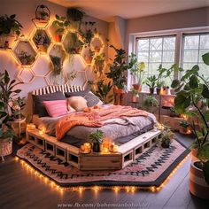 a bed with lots of plants and lights on the headboard is surrounded by potted plants