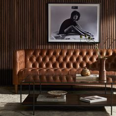 a brown leather couch sitting next to a table