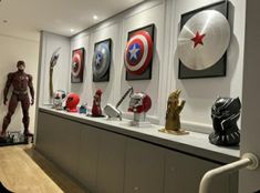 a display case filled with captain america masks and figurines on top of shelves