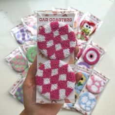 a person holding up a card covered in pink and white crocheted material with owls on it