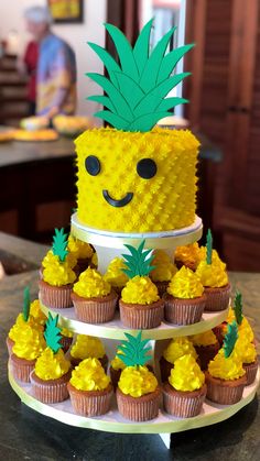 a pineapple themed cake with cupcakes on top