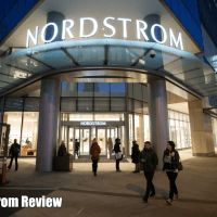 people walking in front of a building at night with the words nordstrom on it