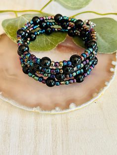 The adorable black and multi color bead memory wire bracelet. Made in the USA. This bracelet is the perfect accessory for any womens wardrobe.  This bracelet is a great womens gift.  Memory wire bracelet will fit any wrist and never loose its shape. Black Stretch Bracelet With Spacer Beads As Gift, Adjustable Black Stretch Bracelet With Spacer Beads, Black Bangle Jewelry With Colorful Beads, Black Bangle With Colorful Beads, Multicolor Spiritual Bracelets With Black Beads, Black Bohemian Wrap Bracelet With Round Beads, Spiritual Beaded Black Wrap Bracelet, Spiritual Black Beaded Wrap Bracelet, Black Beaded Bracelets With Spacer Beads As Gift