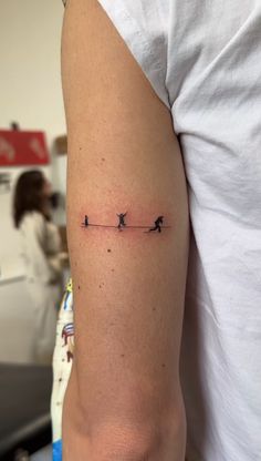 a person with a small tattoo on their arm that has birds flying across the line