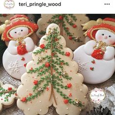 christmas cookies decorated like snowmen and angels on a table with pine cones in the shape of trees